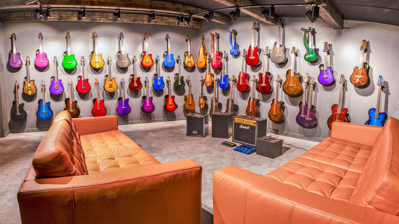 Emerald Guitars Factory Tour players suite with many colourful guitars and leather sofas