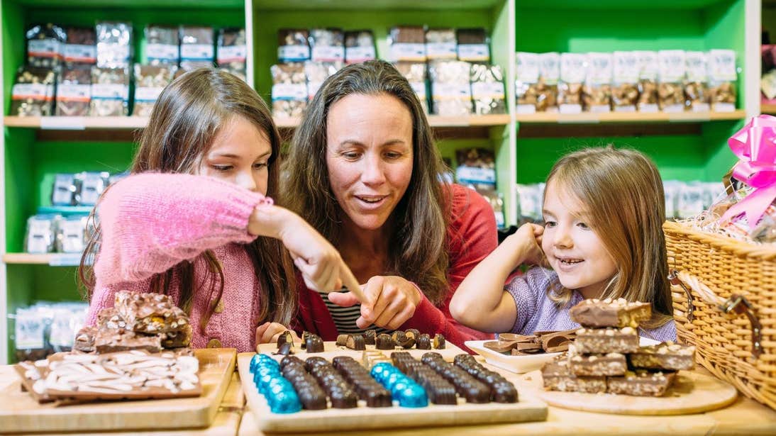 Woman and two young girls looking at a counter full of chocolates Wilde Irish Chocolates, Clare