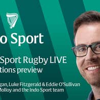 A smiling man in blue shirt with background of green stripes and white text