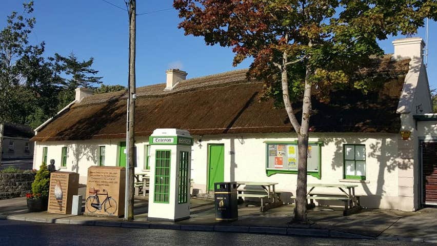 A white washed traditional cottage with a thatched roof
