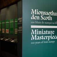 Large sign in dark green with white text at the entrance to a display in a museum