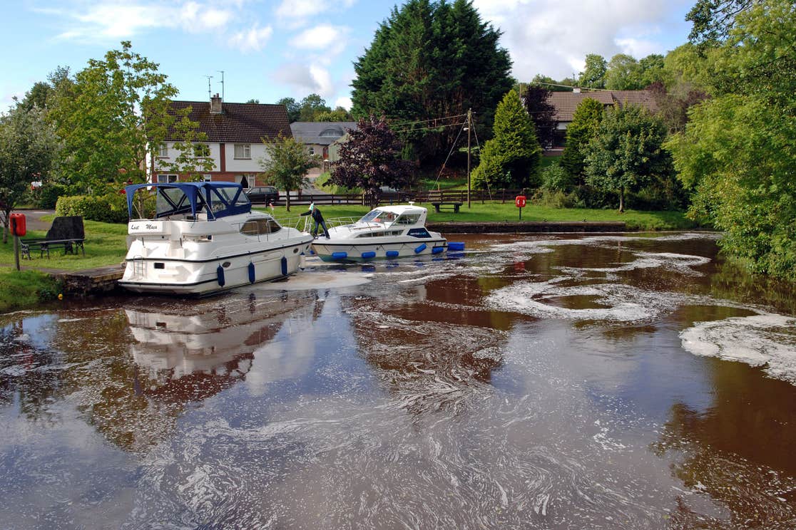 Two boats on the harbour in Ballinamore in County Leitrim near a park