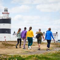 Five people walking up to Hook Lighthouse in County Wexford.