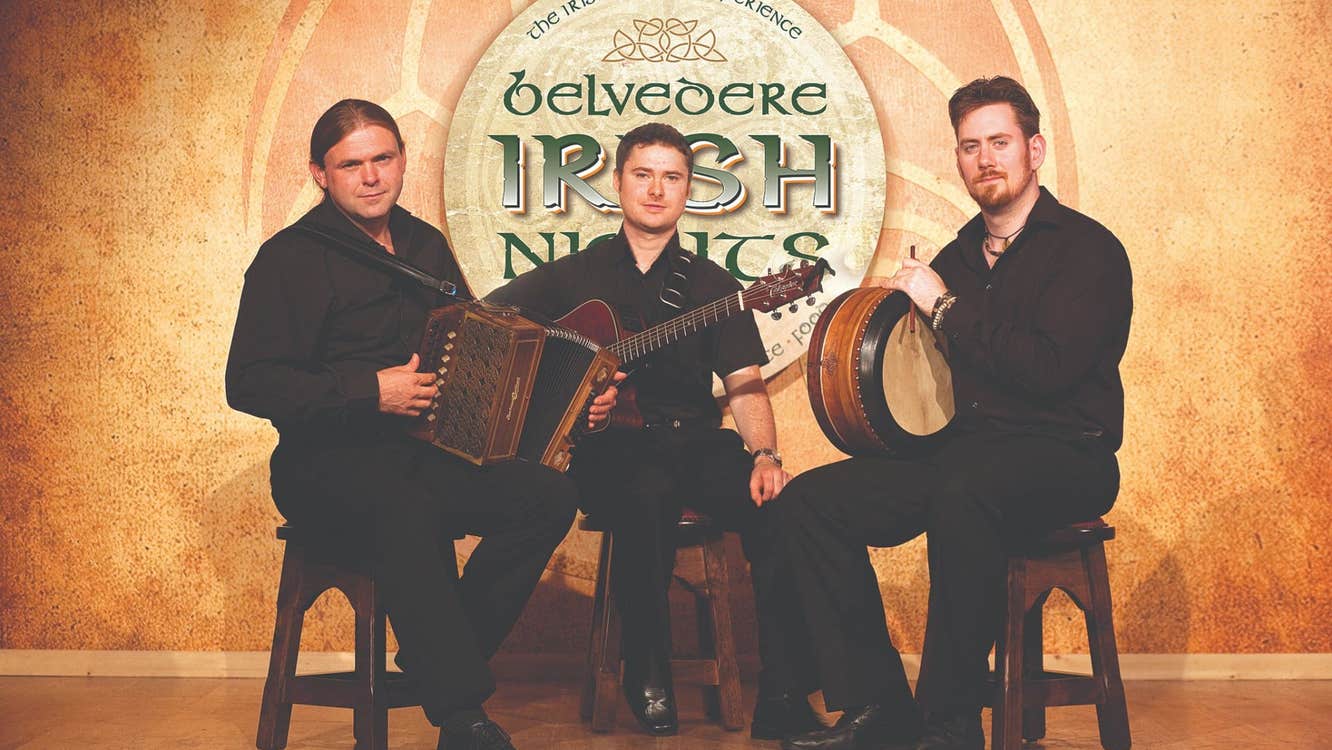 Three traditional Irish music musicians sitting on stools with their instruments