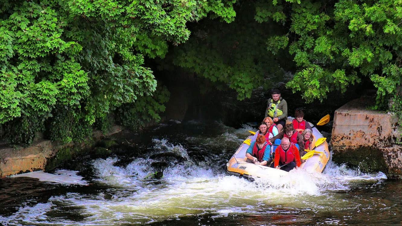 A group of people on a raft going through some rapids