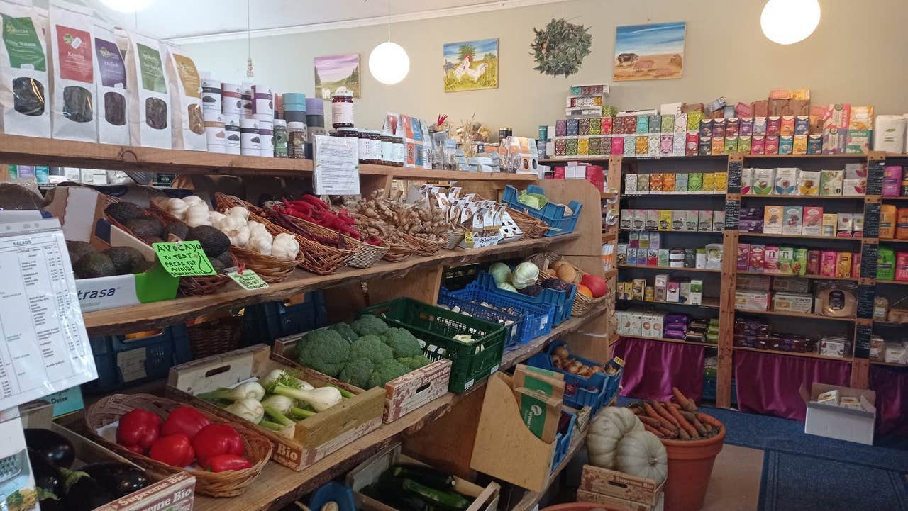 Shelves in a shop with lots of colourful fruit and vegetables along with packaged organic products