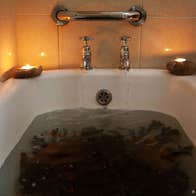 Sea weed soaking in a hot bath of sea water with candles lighting on the bath side