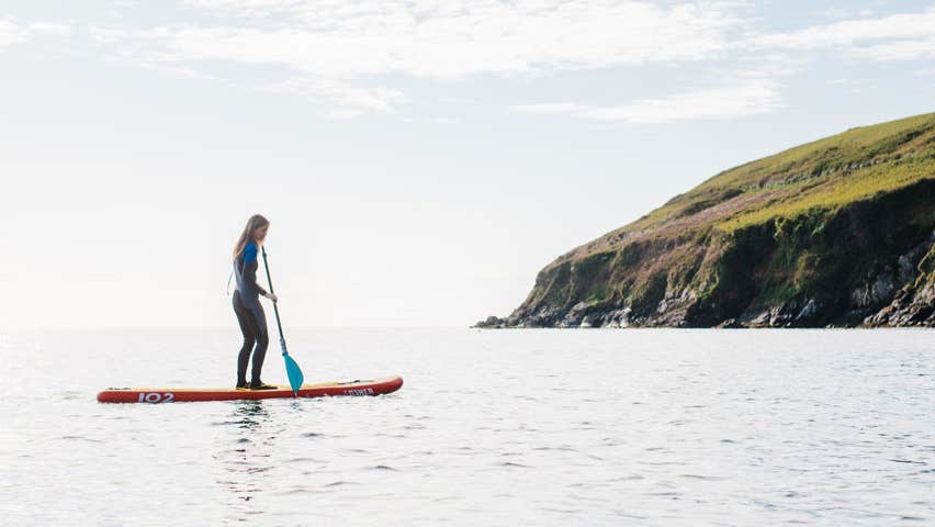 A person on a stand up paddle board out at sea