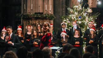 A choir in Christmas hats singing in a church