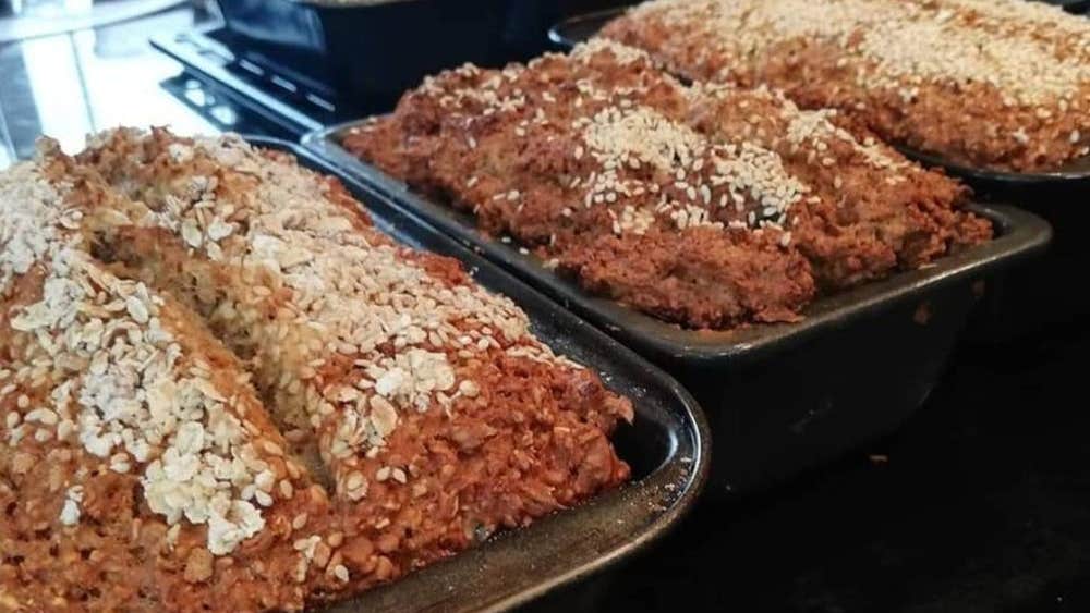 Freshly baked loaf tins of brown bread cooling on racks in the Just Cooking kitchen