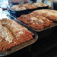 Freshly baked loaf tins of brown bread cooling on racks in the Just Cooking kitchen