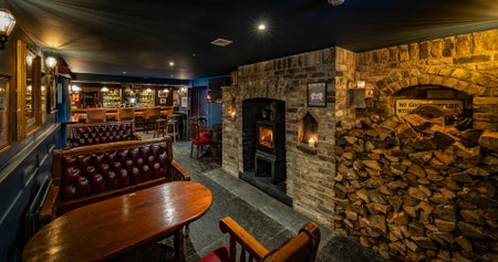 A view of the bar area with a fireplace at The Golden Ball Kilternan