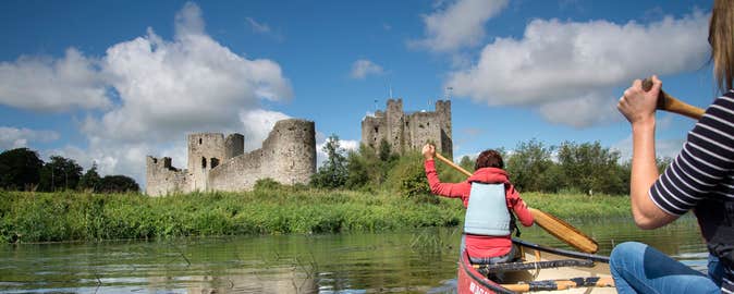 Two ladies in a canoe on the River Boyne near castle ruins