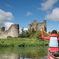 Two ladies in a canoe on the River Boyne near castle ruins