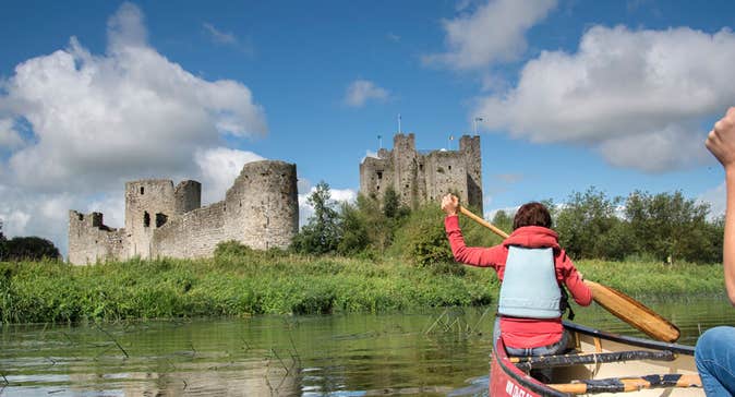 Two ladies in a canoe on the River Boyne near castle ruins
