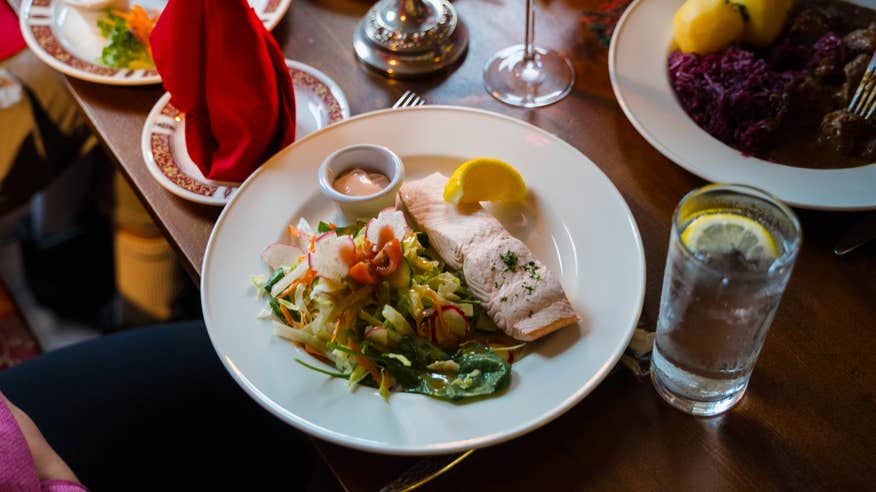 Dinner plate of fresh salmon and vegetables at a restaurant.