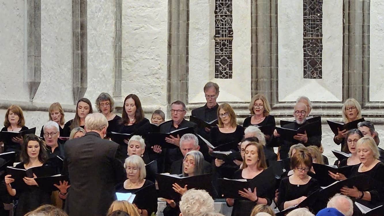 A photo of two choirs, Cór Mhaigh Eo and Louisburgh Voices, in Ballintubber Abbey, Mayo
