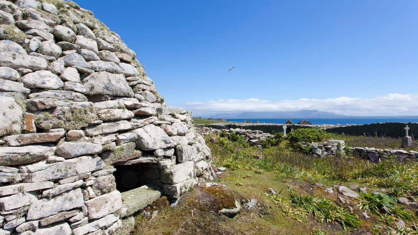 Stone structure with scrub land and sea in the distance
