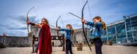 The castles resident archer with two girls all holding their bow and arrows in the courtyard
