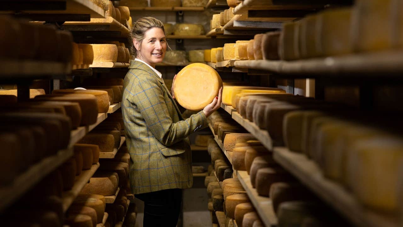 A lady holds an Irish farmhouse cheese wheel at Kylemore Farmhouse