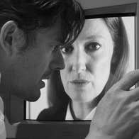 A man is looking closely at an image of a woman's face.