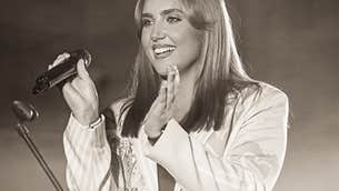 Stacey Breen Dance, a smiling woman holding a mike, clapping her hands