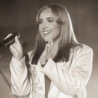 Stacey Breen Dance, a smiling woman holding a mike, clapping her hands