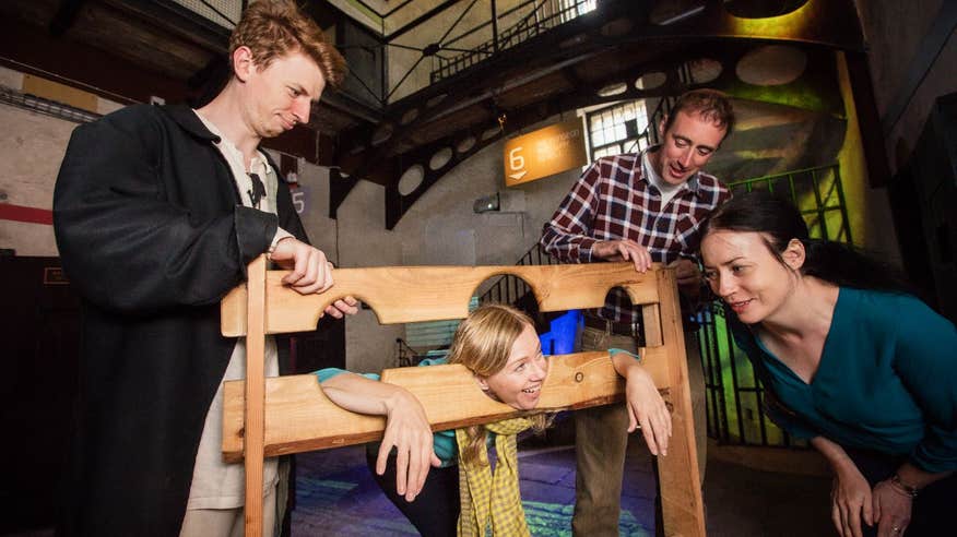 A group of friends playing with old jail tools in Wicklow Historic Gaol, County Wicklow