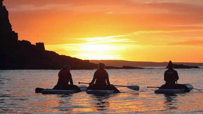 Paddlers in the water watching the sun rise