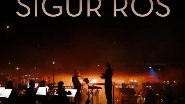 Band SIGUS RÓS with The Ulster Orchestra, dimly lit view of an orchestra and conductor on a stage with orange lights