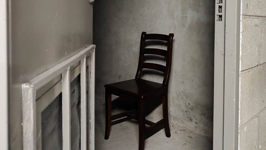 A lone chair in a small, scruffy room
