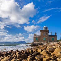 A small lighthouse beside a rocky coastline