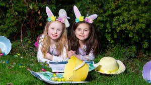 Easter Trail Strokestown Park, 2 young girls laid on grass with easter bunny ears, baskets and eggs
