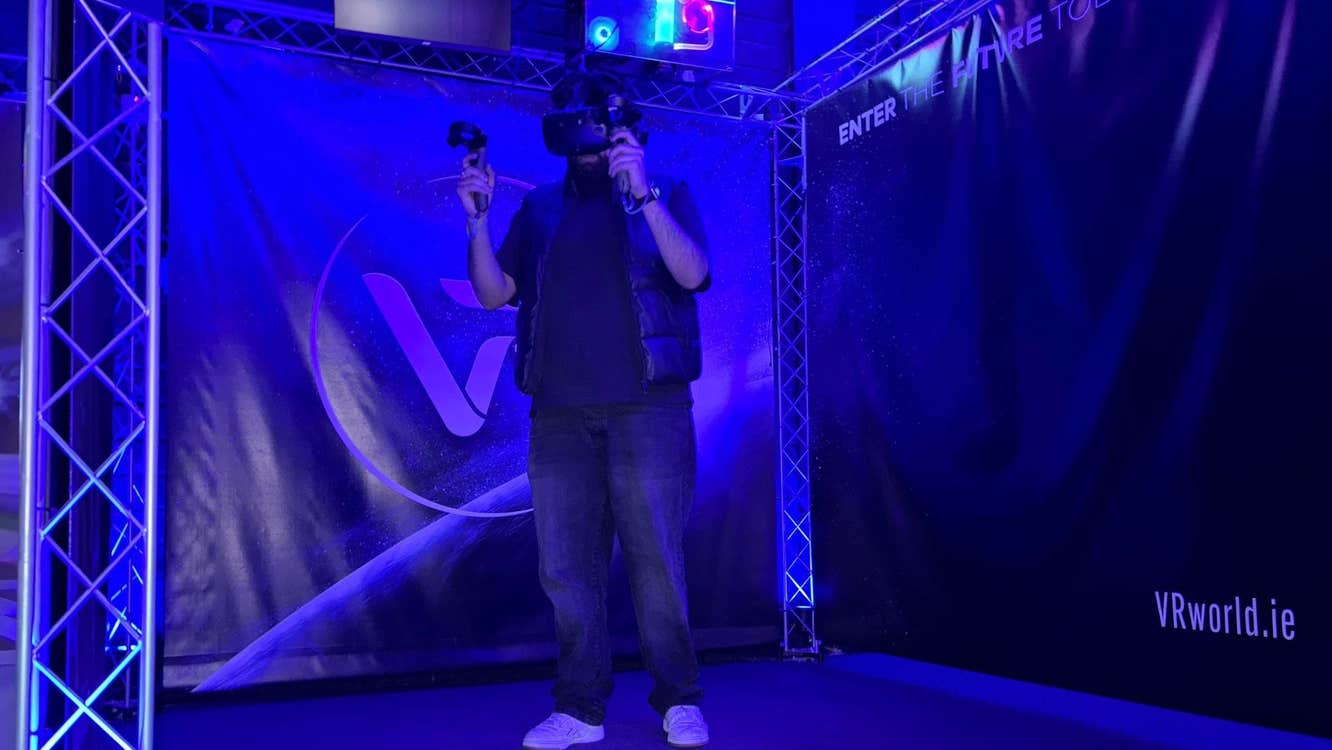 Person standing alone in a dark room using a virtual reality headset