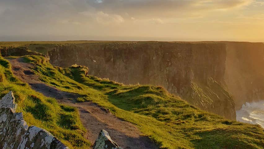 A grassy cliff path along a cliff edge