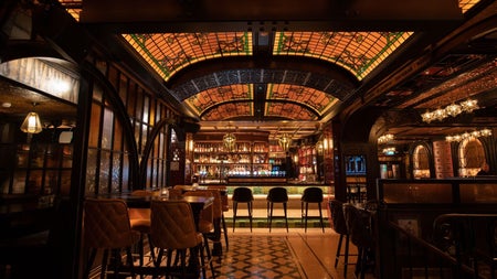A view of the Whiskey Bar at Murray's Bar & Grill with a striking stained glass ceiling and patterned flooring