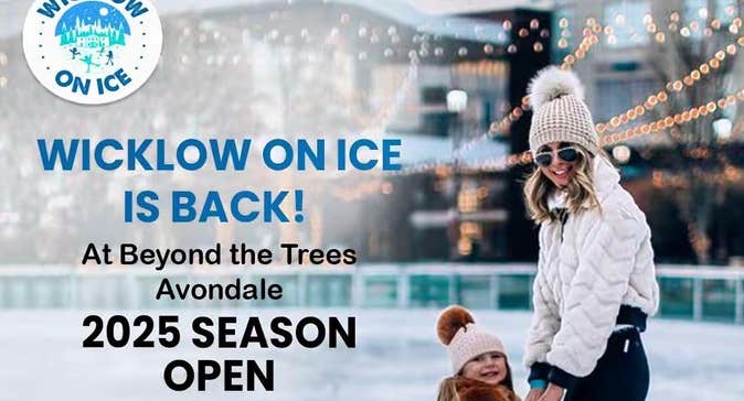 A adult and small child on an ice rink in wooly hats.