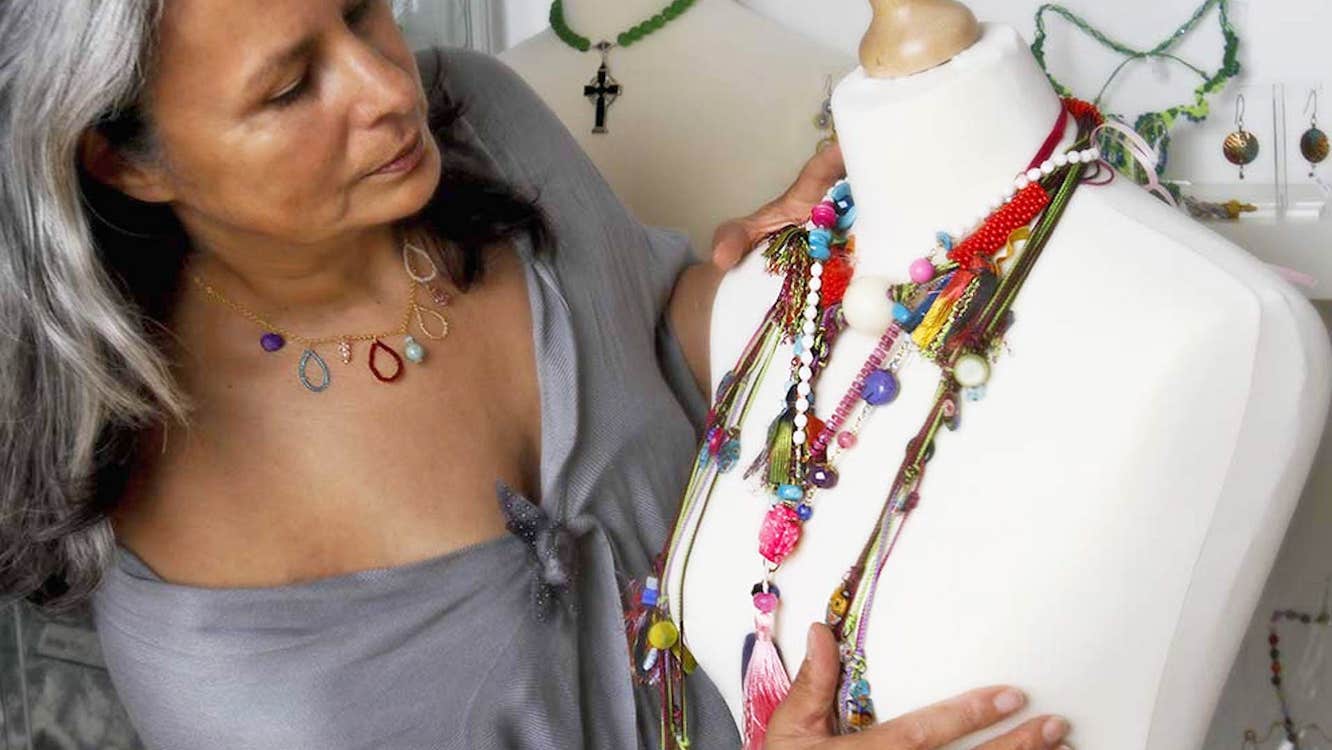 Jewellery Making with Victoria Foutz view of the artist with necklaces of colourful and varied materials