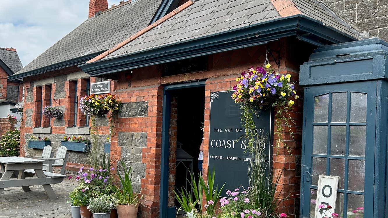 The main entrance to Coast & Co with a painted vintage telephone box beside it