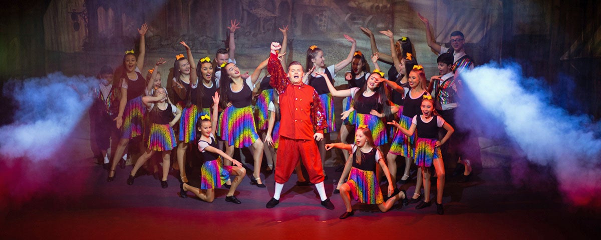 The cast of a show in posed position at the finale of a performance