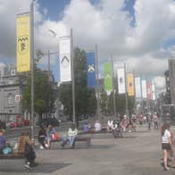 A street view of the heraldic flag poles at Eyre Square in Galway City