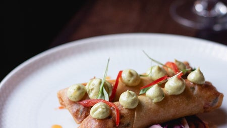 A white dish with two pastry rolls colourfully decorated