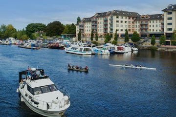 Boats of and row boats sailing down the river in Athlone.