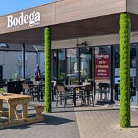 Exterior of a café with a dining area outside the door and on the paved street