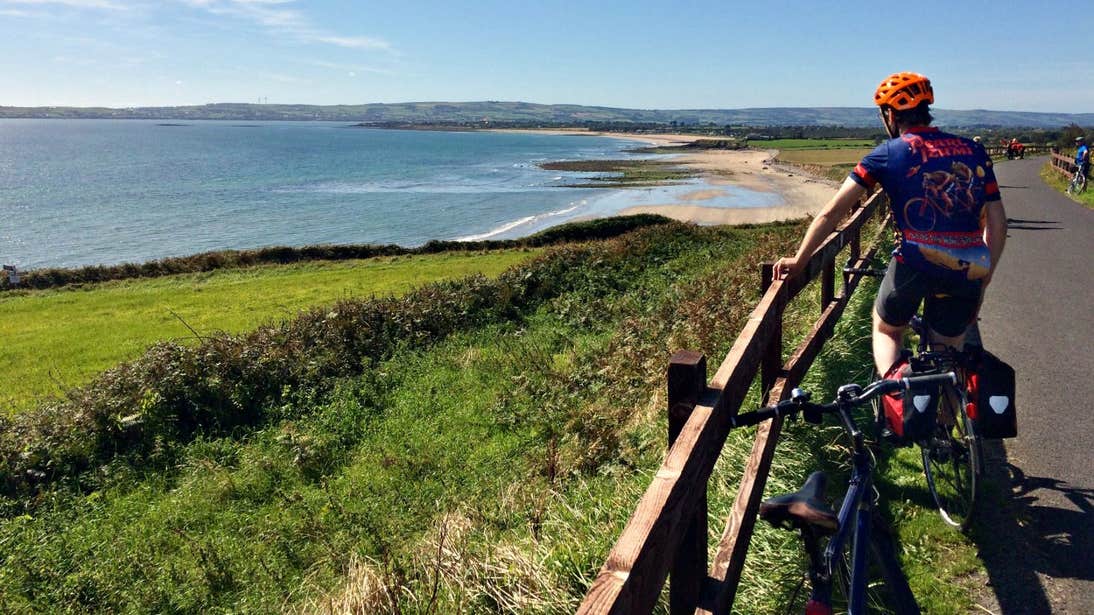 A cyclist admiring the incredible coastal views on the Waterford Greenway