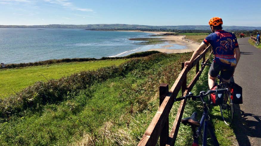 A cyclist admiring the incredible coastal views on the Waterford Greenway