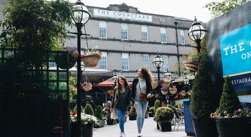 Two friends walking through a market in Cork City