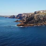A boat sailing past a headland