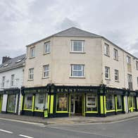 Black and yellow painted shop front with and windows and an open door