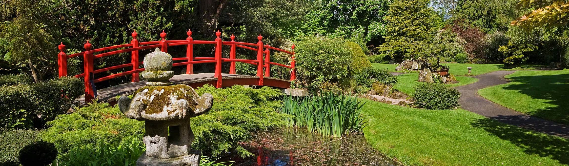Walking over the red bridge going over a river in the Japanese Gardens is one of the best things to do in Kildare